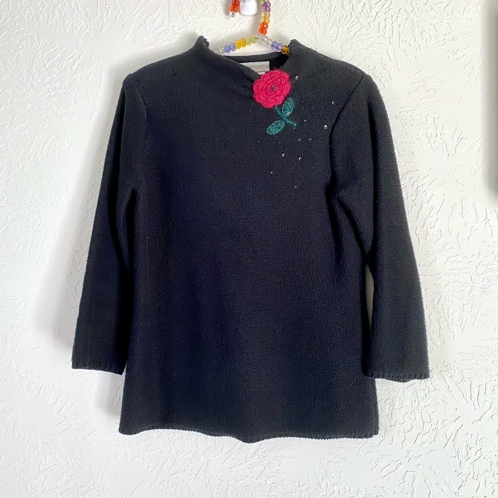 Black sweater with an eye catching flower and sequin’s design.